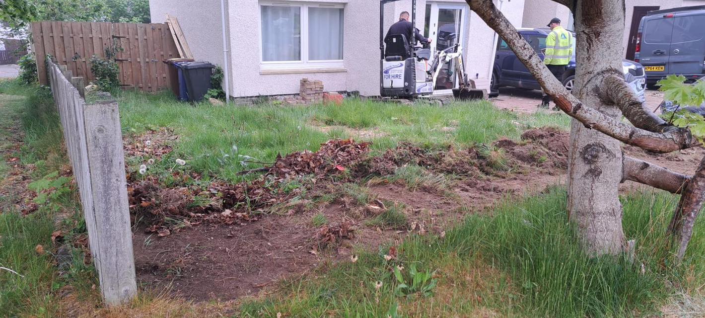 mini excavator removing overgrown garden