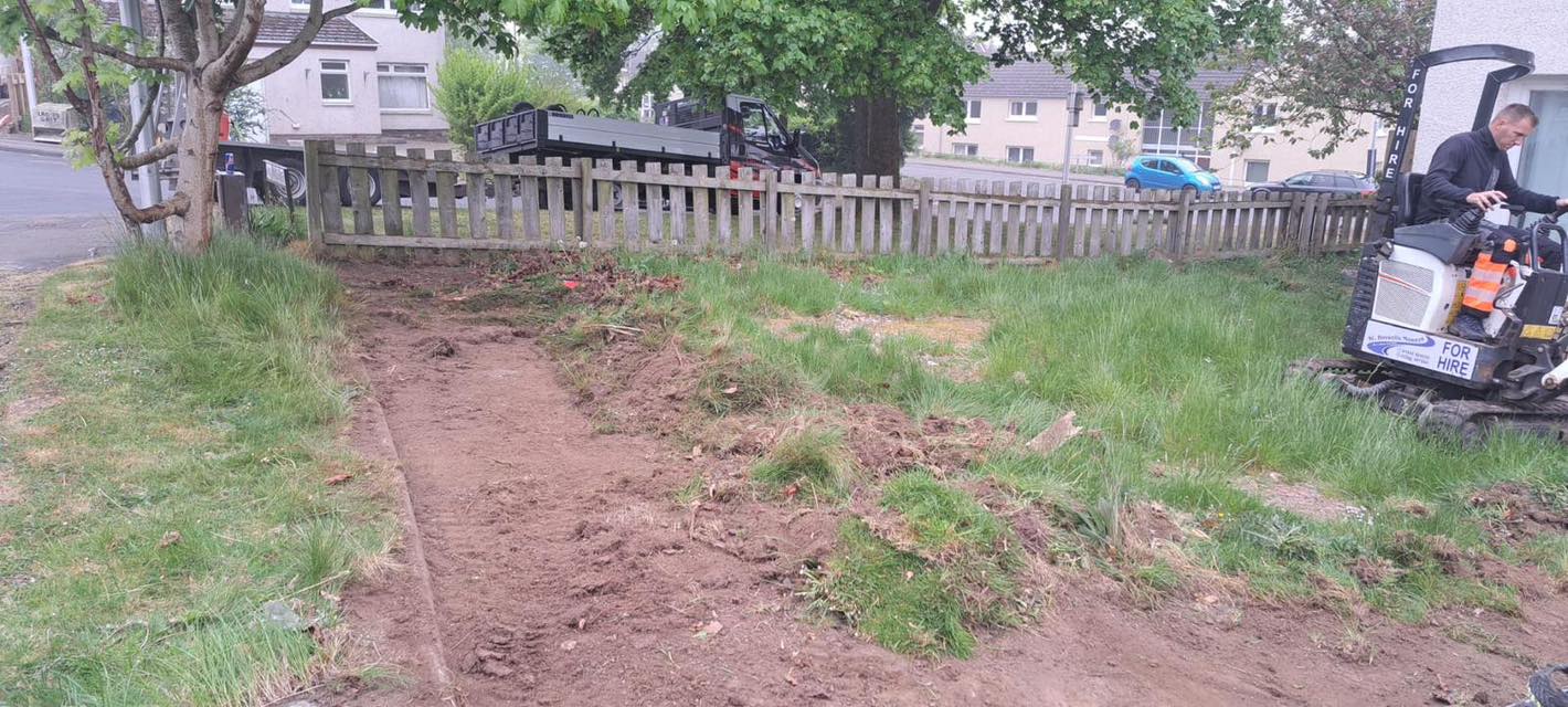 mini excavator removing overgrown garden