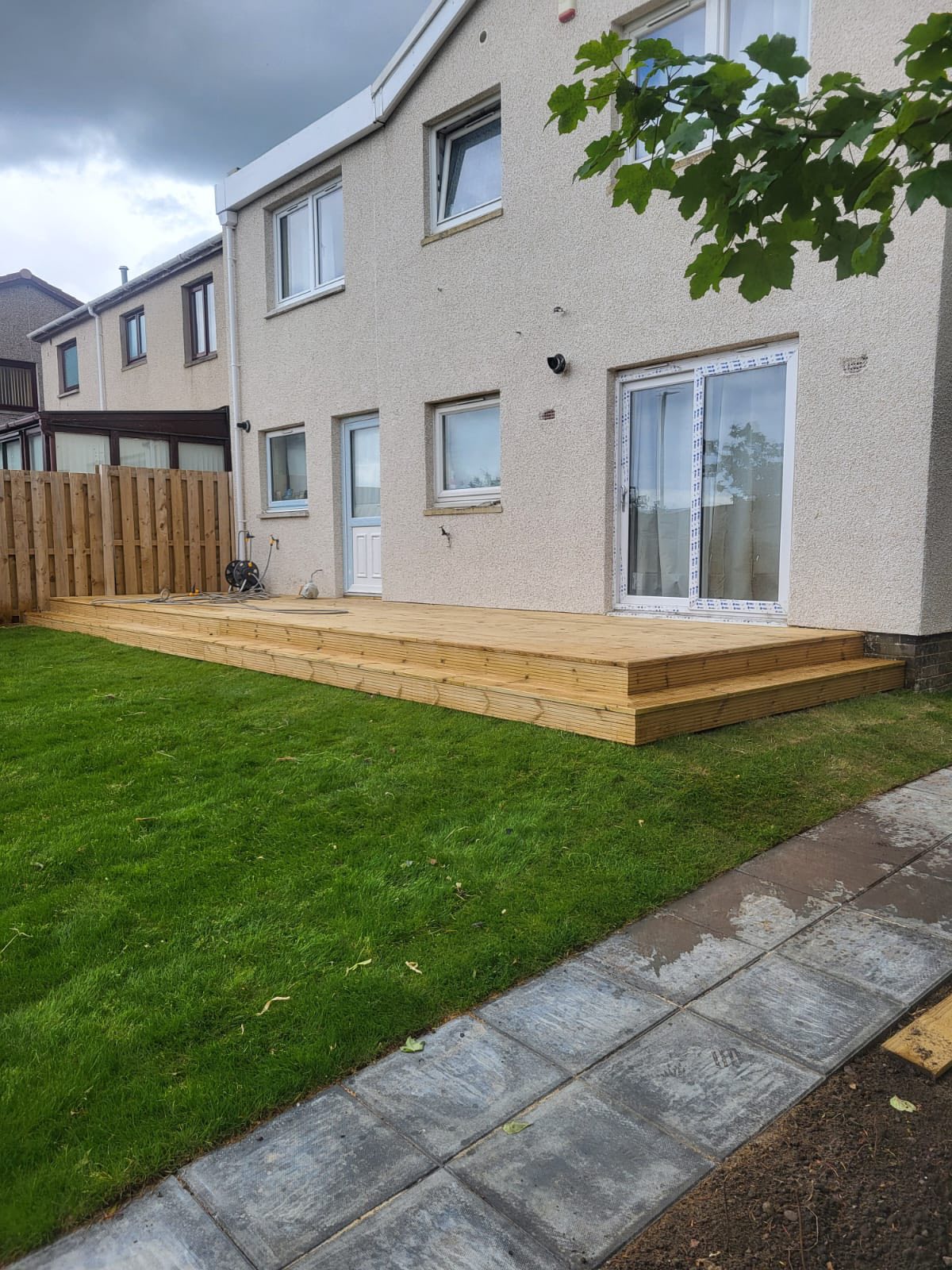 view of new decking, slabbed path and newly laid back lawn