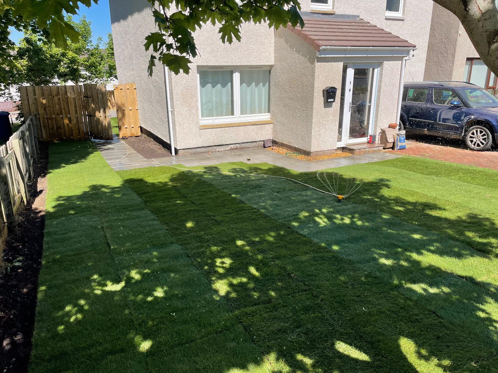 newly turfed front lawn being watered