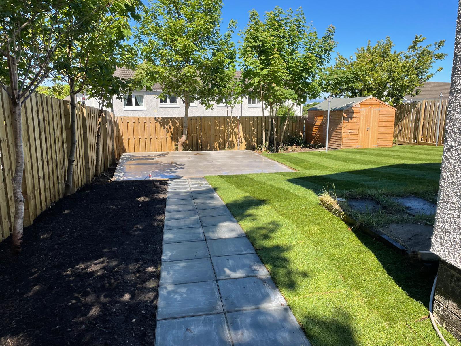 back garden view of new path, lawn and summer house area